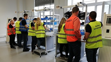 Das Bild zeigt Studenten der EAFIT Universität in einem Labor. Sie stehen an großen Geräten.